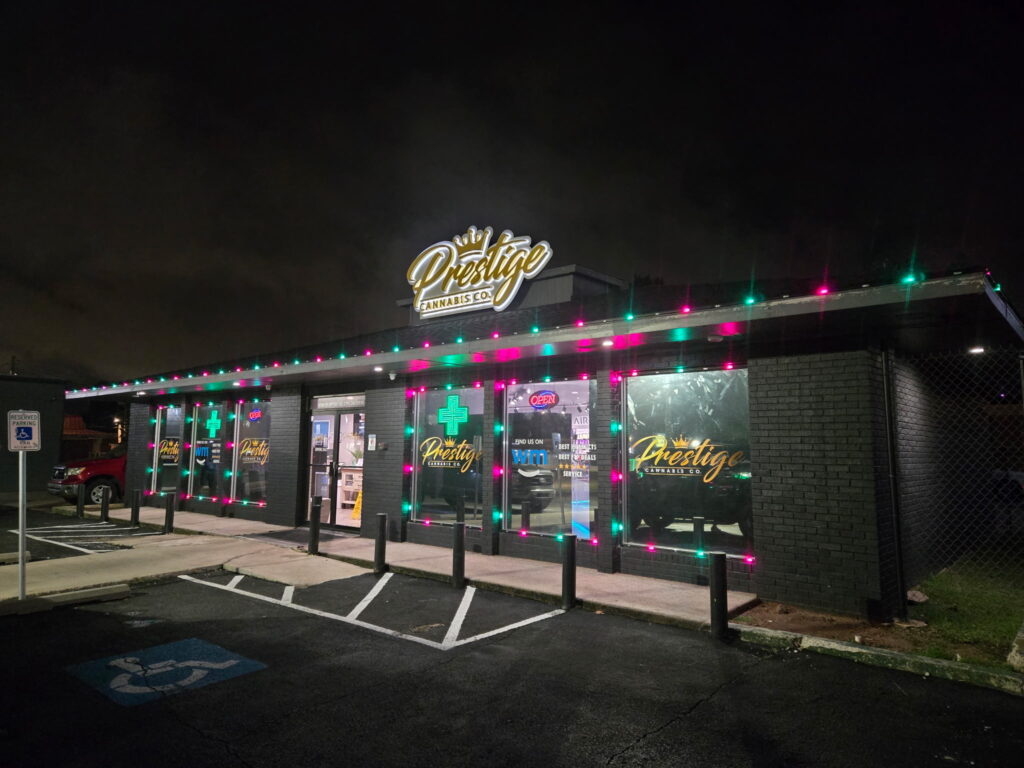 Retail storefront decorated with permanent holiday lighting in red and green for Christmas season
